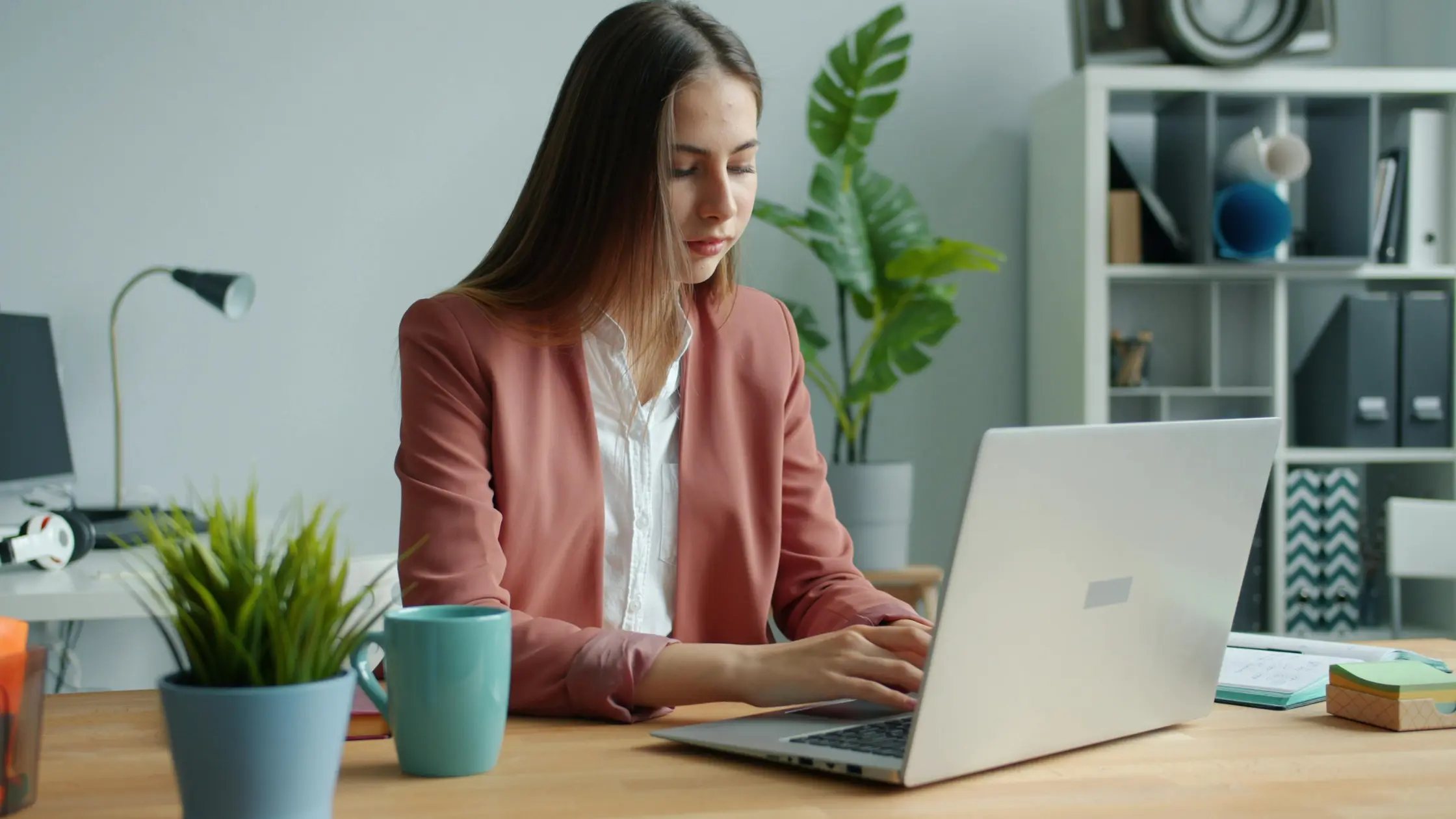 A young female landlord working on a laptop and setting up a rent collection account.