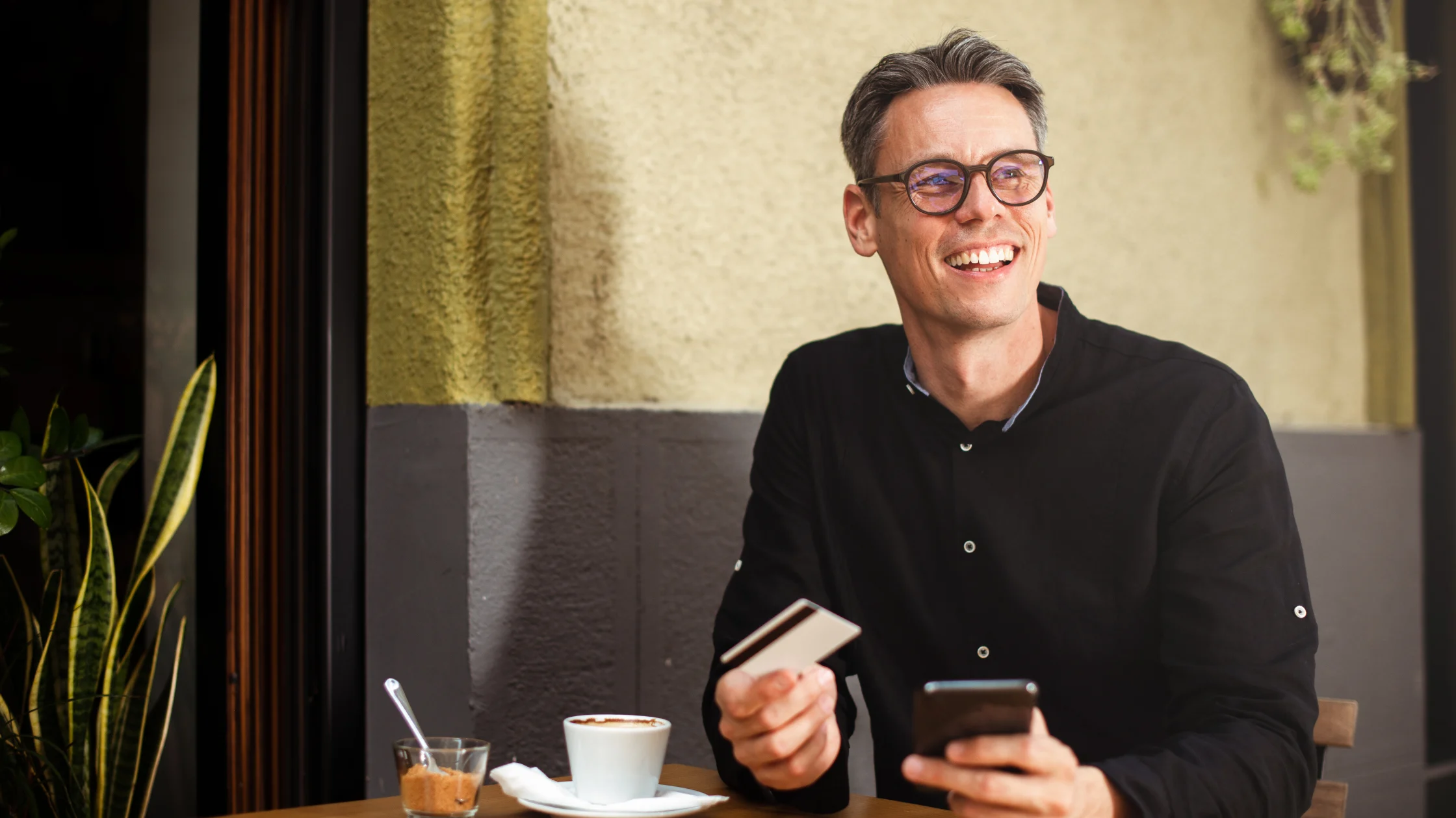A landlord drinking a coffee and smiling after reading about common rent collection problems and how to solve them.