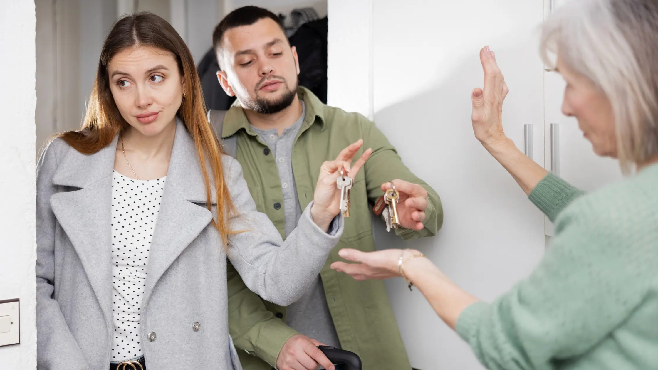 Two tenants handing over rental property keys to the landlord.