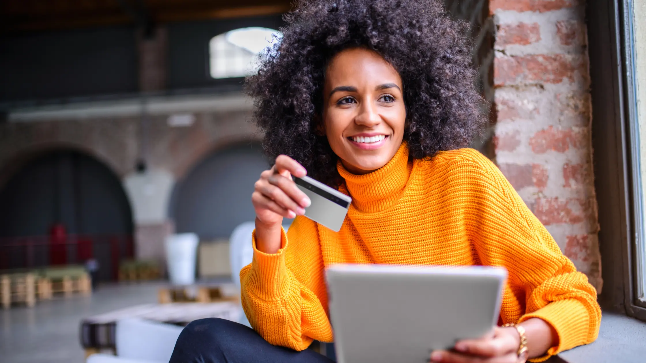 A woman reviewing rent collection tips while holding a payment card.