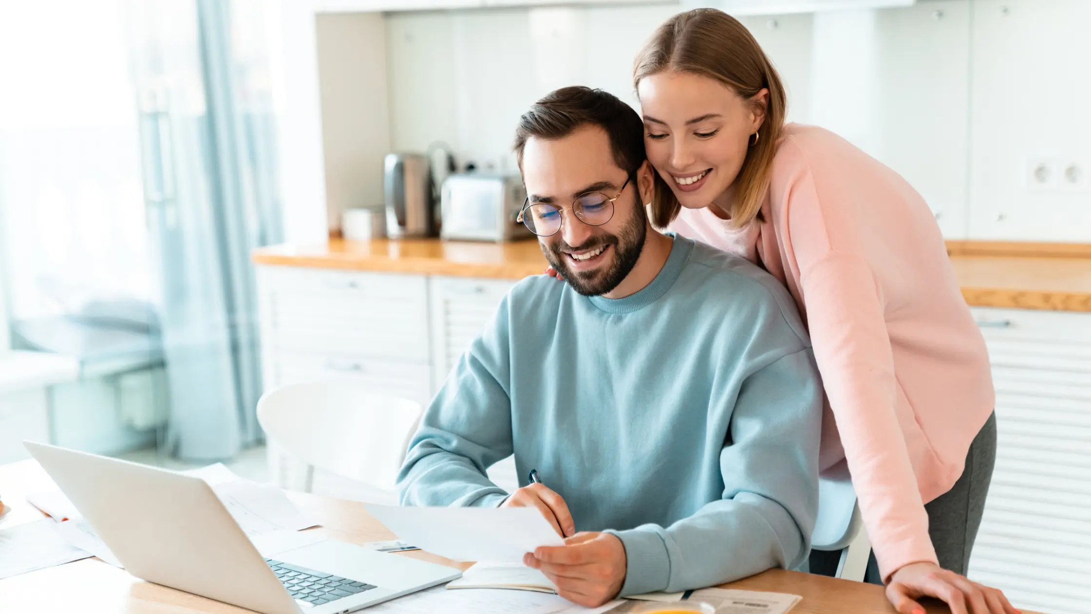 A couple reviewing Royal Invest's credit check reports on a laptop.